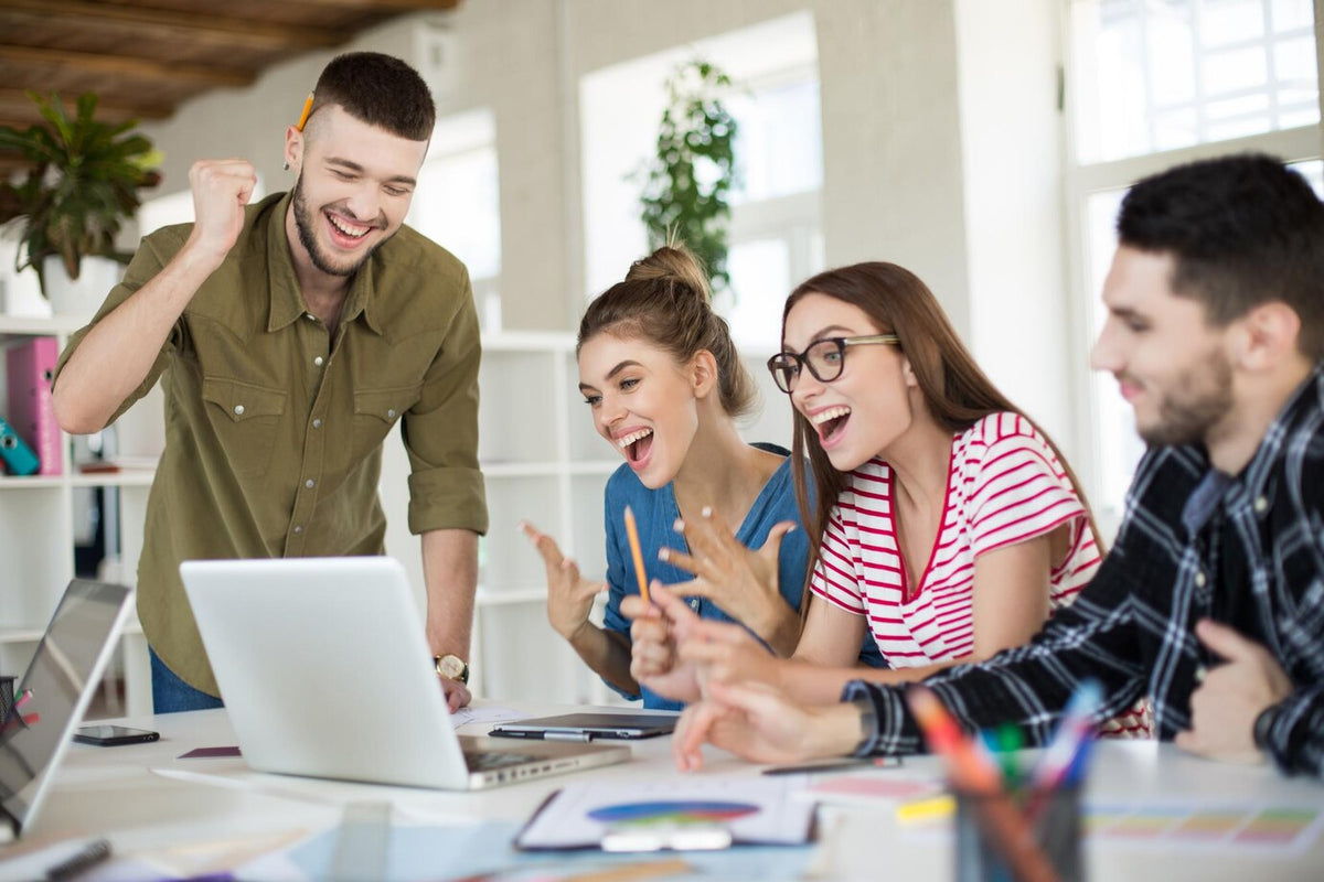 Affiliate marketing team celebrating success working on partnership program in modern office
